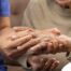 A care provider examines an older adult’s fingers, representing what would happen in an examination for rheumatoid arthritis.